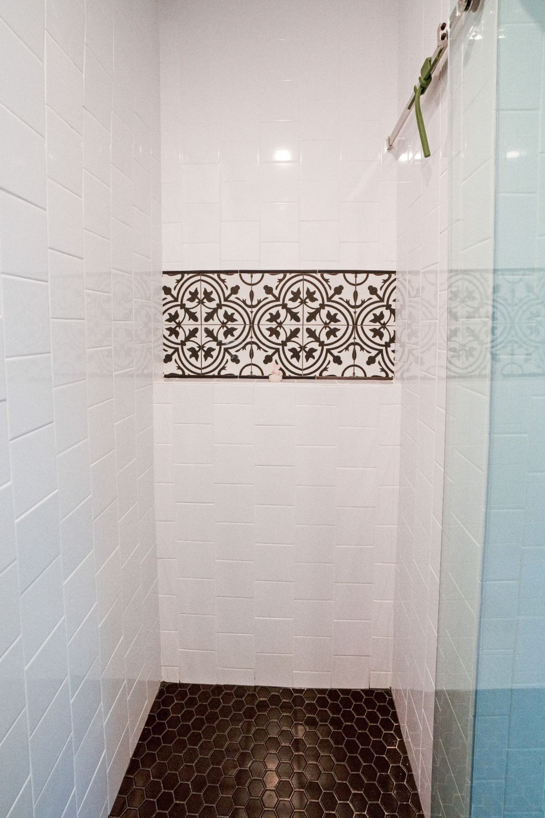 Shower interior with ornate Moroccan tile accent strip