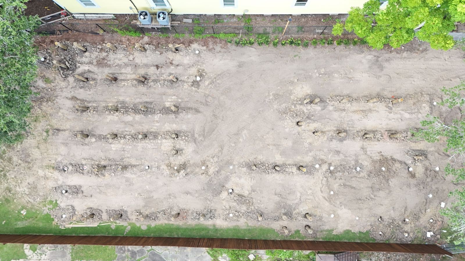 Professional drone aerial showing completed labyrinth paver plaza next to pavilion with lake beyond