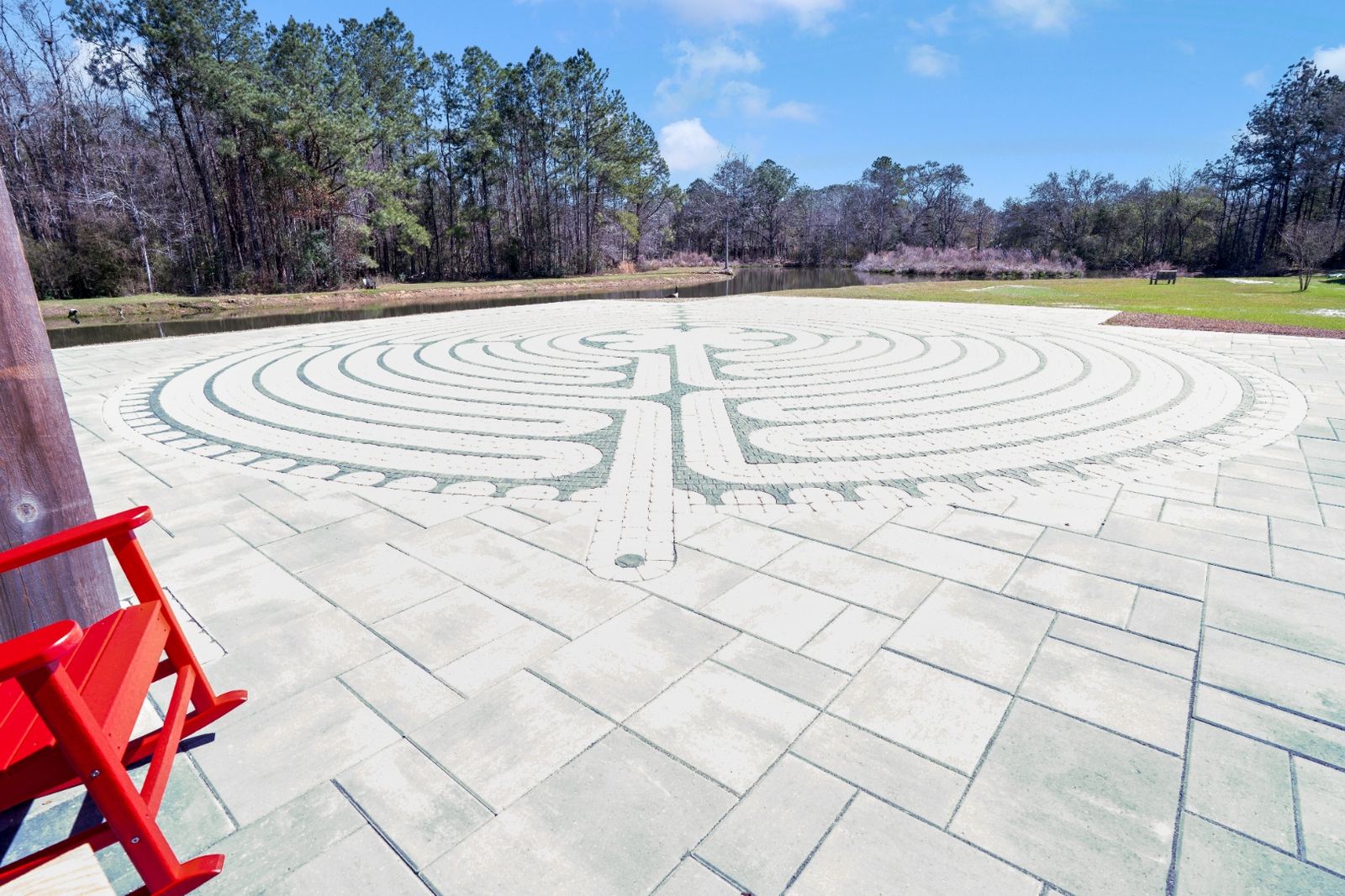 Custom labyrinth paver pattern with timber pavilion and pond