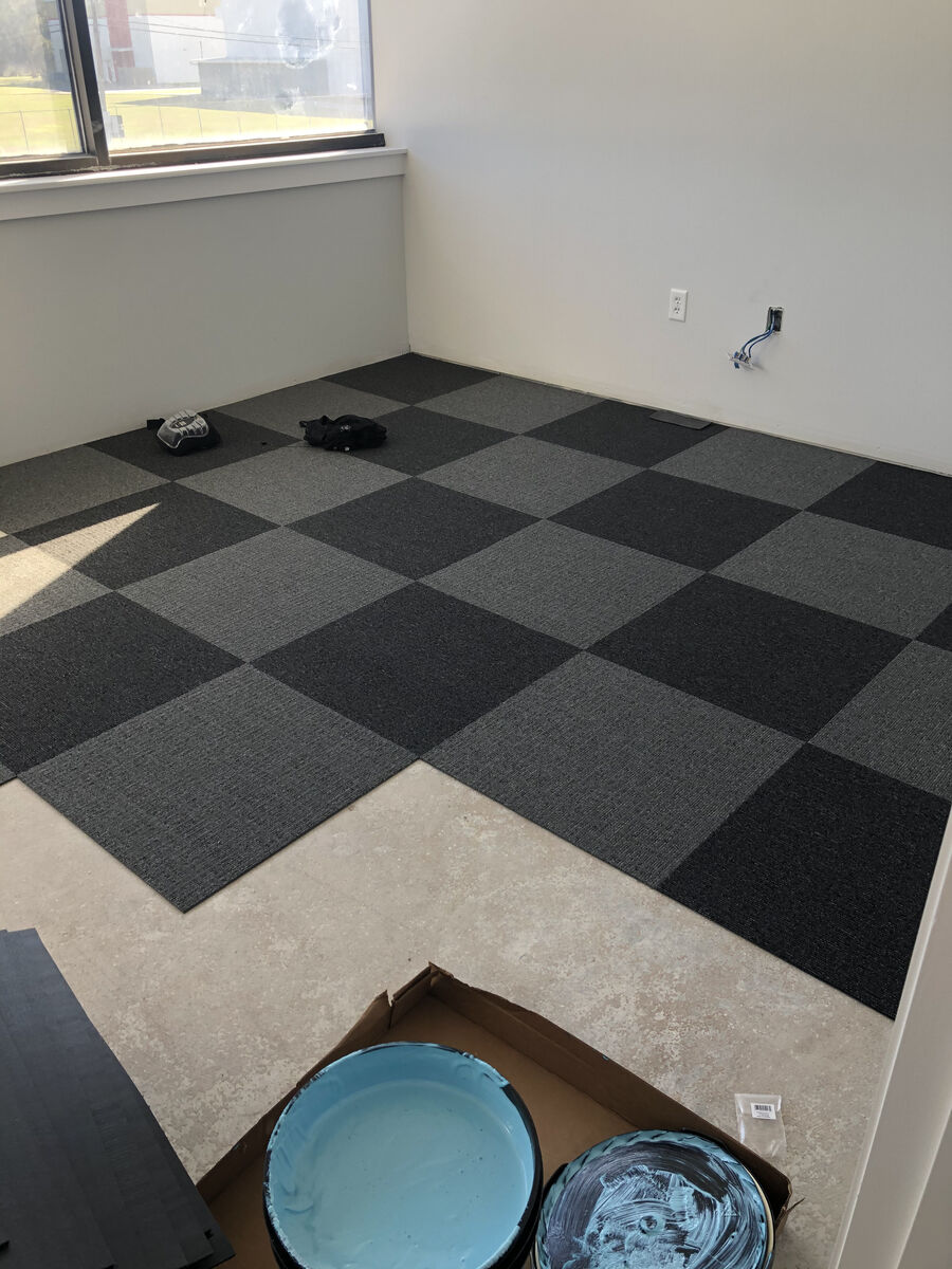 Commercial office carpet tile installation in checkerboard pattern — interior build-out in progress