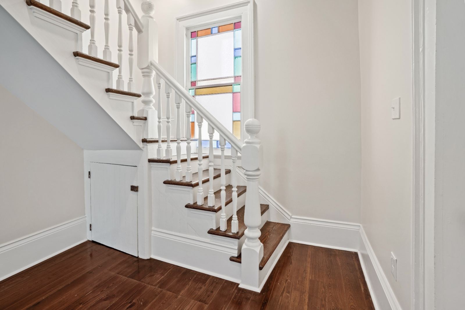 Restored historic staircase with stained glass transom window