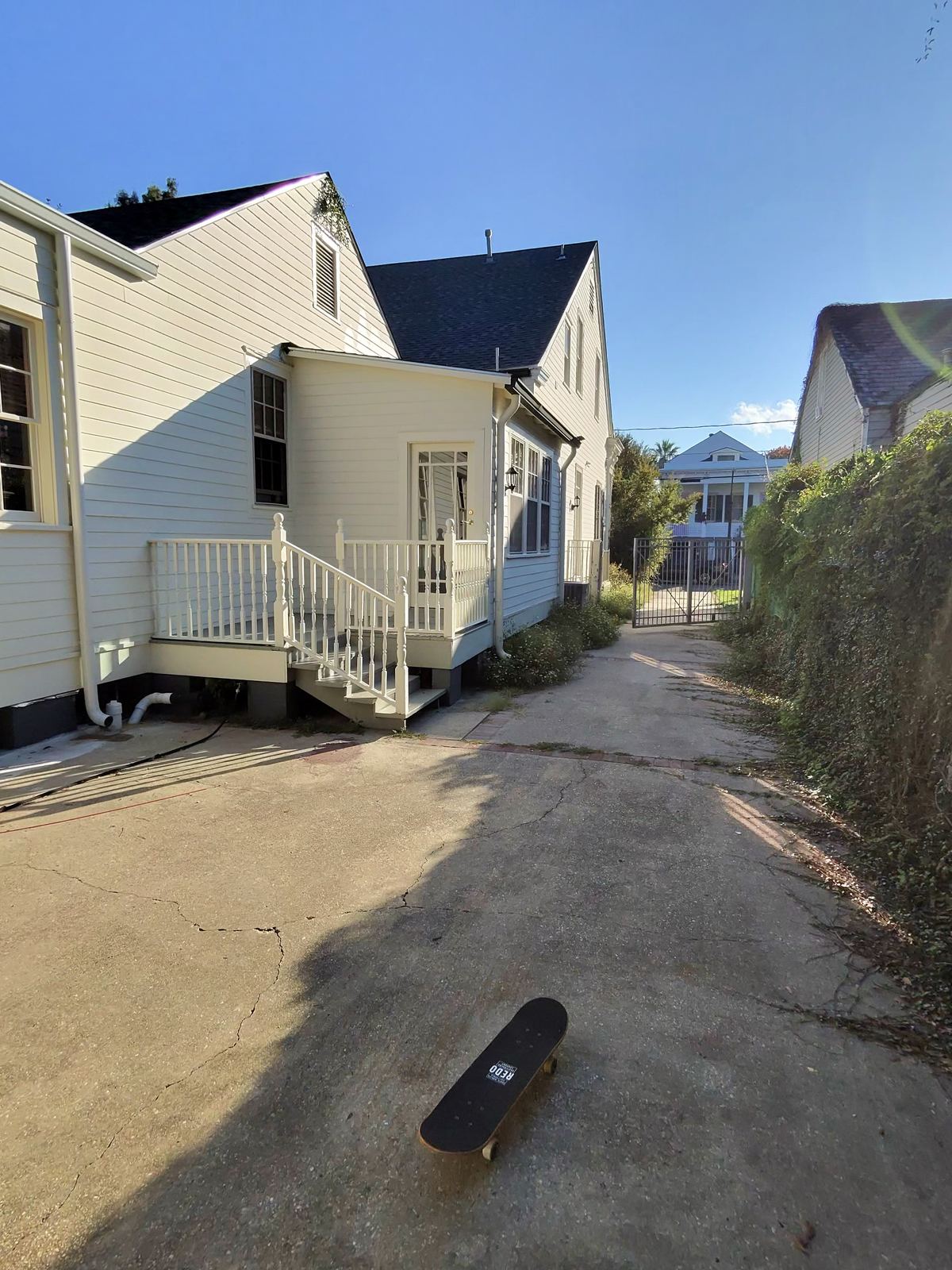 Beautifully restored historic New Orleans home with amber front door, ironwork gate and haint blue porch ceiling
