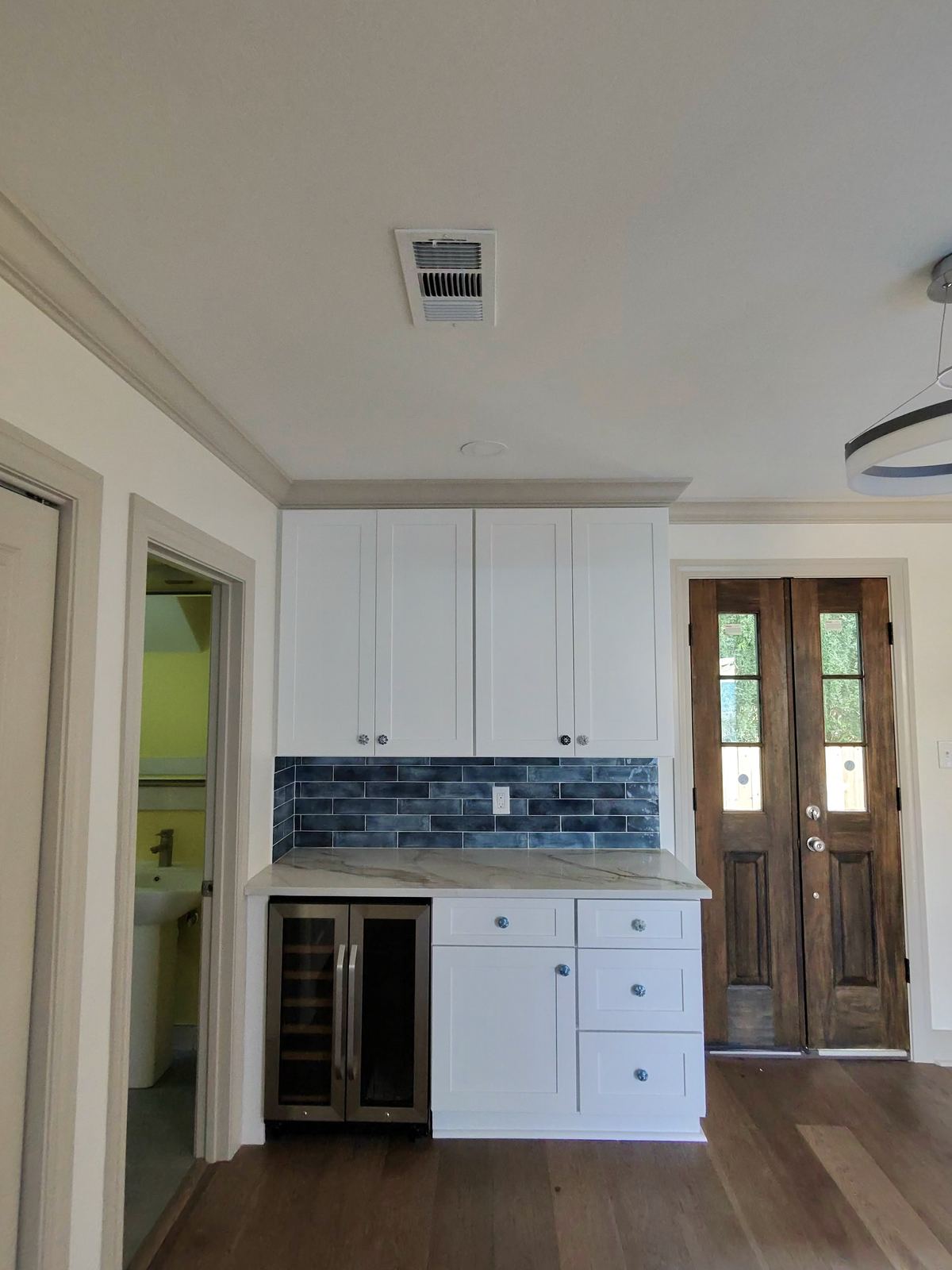 Kitchen sink wall with blue subway tile and marble quartz countertops