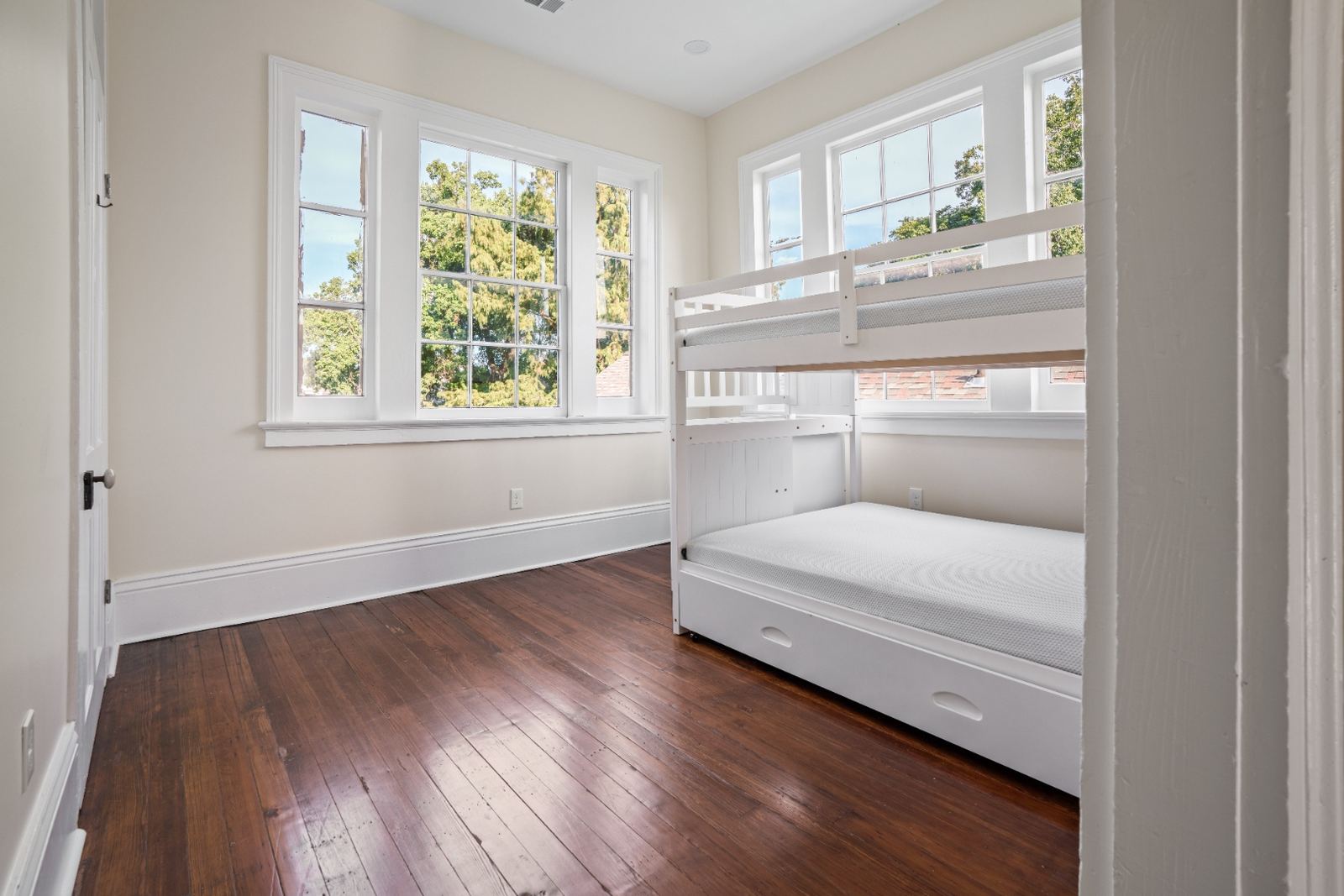 Renovated child bedroom with original hardwood floors and double windows