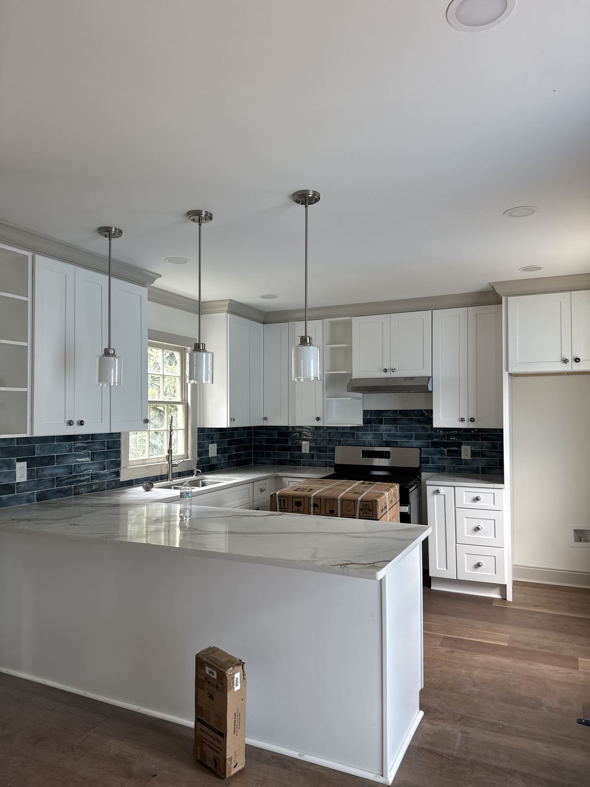Dramatic foyer with crystal chandelier, black board-and-batten paneling and dark staircase