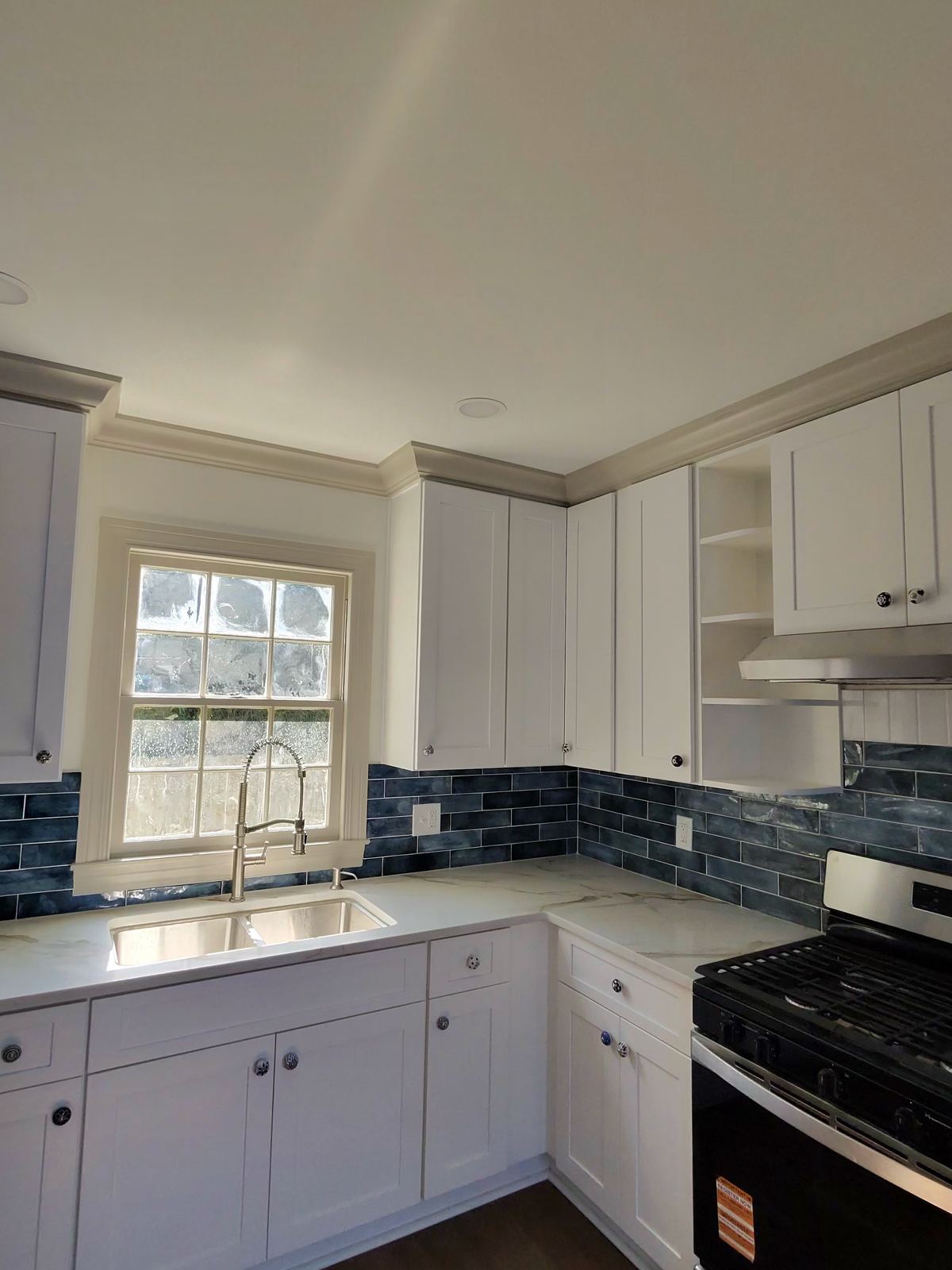 New construction living area with dark wood staircase and wide plank hardwood floors