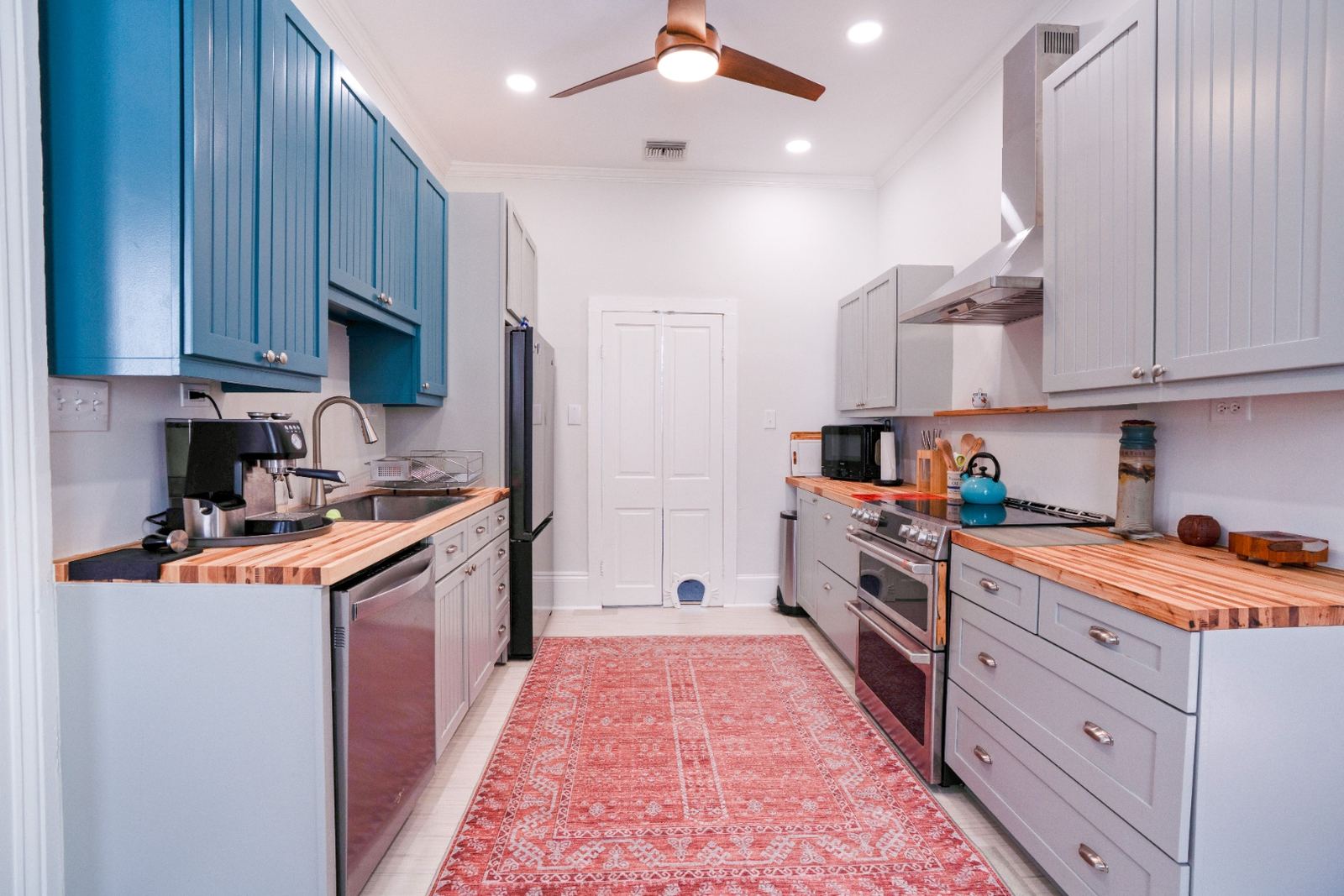 Teal and gray galley kitchen with butcher block counters
