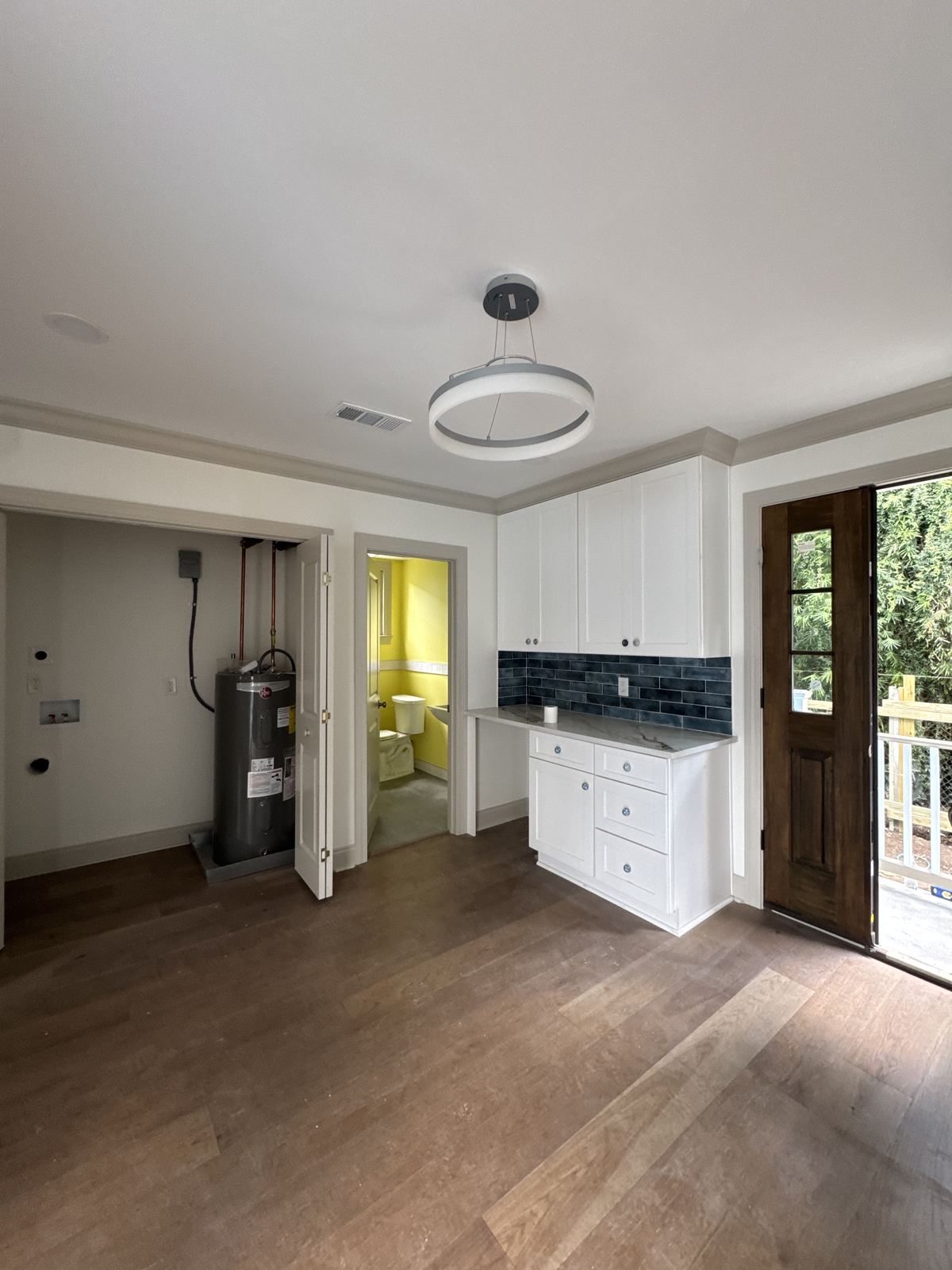 White shaker kitchen with marble waterfall island and blue subway tile backsplash