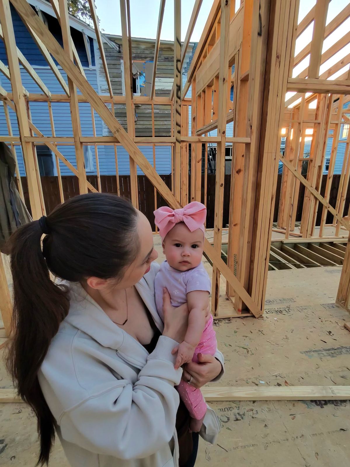 A mother and baby on the framing of their new home